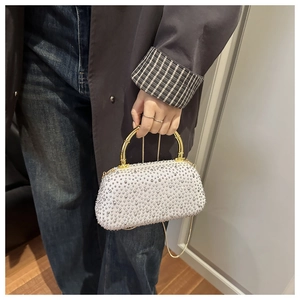 Dettaglio della borsa da sera bianca con strass argento e manico in bambù dorato