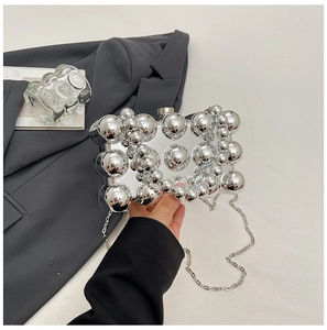 Detail der silbernen Kugel-Abendtasche mit glänzendem Chrom-Finish und Kettenriemen