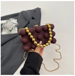 Detailansicht der dunkelvioletten 3D-Acryl-Tasche mit goldenem Perlen-Griff und langer Kette