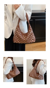 Detail of a brown leather hobo bag with silver rivets and sleek zipper closure