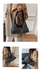 Detail shot of black semi-circle underarm bag with silver round rivet decorations