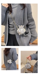 Detail of silver lucky bag crossbody bag with metal floral relief and gold chain