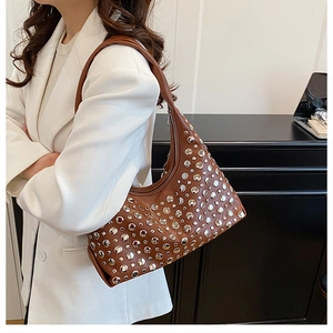 Close-up of brown hobo bag with silver metallic studs and side zipper detail