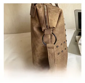 Detail of vintage brown tote bag with metal rivets and sturdy zip closure mechanism