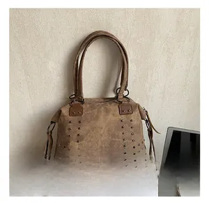 Detail of vintage brown suede tote bag with metal studs and zipper closure
