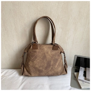 Close-up of vintage brown tote bag with washed texture and metal ring hardware