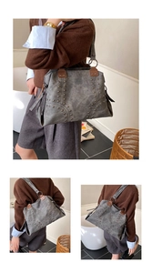 Detail of dark gray vintage tote bag featuring metallic rivets and brown leather handles