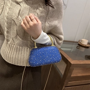 Borsa da sera in acrilico blu reale con borchie argento e manico dorato su modella