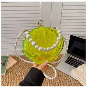 Close-up of shell-shaped acrylic jelly bag with pearl chain and gold metal clasp