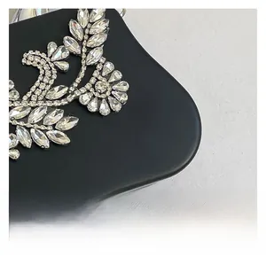 Close-up of sparkling crystal flower rhinestones on premium black matte chain bag