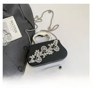 Macro shot of mini black rhinestone box clutch with heart handle and chain strap