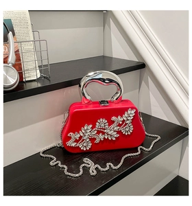 Close-up of red box clutch bag with intricate crystal flower pattern and metal handle