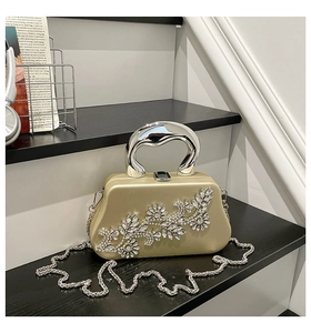 Detailed view of champagne evening bag with intricate silver rhinestone floral patterns