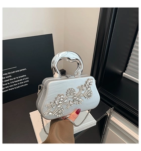 Detail of silver box clutch with crystal floral pattern and metallic top handle