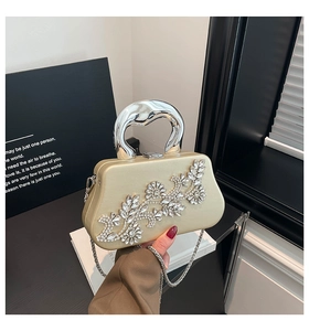 Macro detail of champagne gold box clutch with diamond floral decor and metal handle
