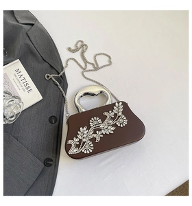 Close-up of a chocolate brown rhinestone evening clutch bag with elegant silver handle