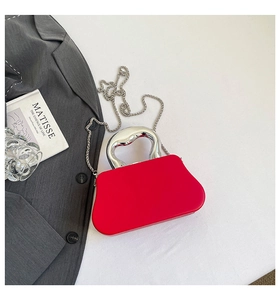 Macro detail of red box handbag with unique silver handle and chain strap for evenings