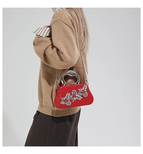 Detail of red box clutch bag with silver crystal flower and metallic top handle