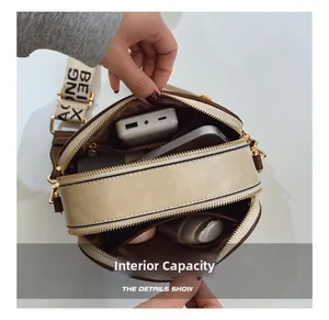 Dual compartment cross-body bag showing ample space for power bank and phones