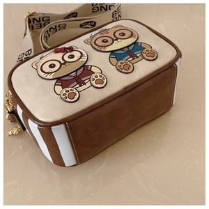 Detail of cartoon cat patchwork bag with wide logo strap and premium gold zipper