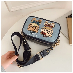 Side view of cartoon cat camera bag with blue matte finish and wide black strap