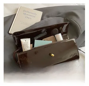 Top view of dark brown patent leather handbag showing interior capacity with essentials
