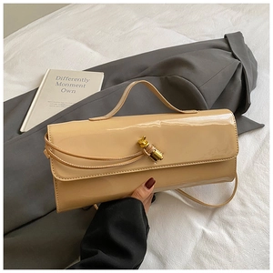 Detail of beige patent leather small square bag with decorative golden twist lock