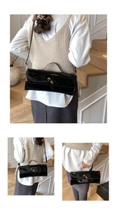 Detail of glossy black patent leather bag with gold twist lock and adjustable strap