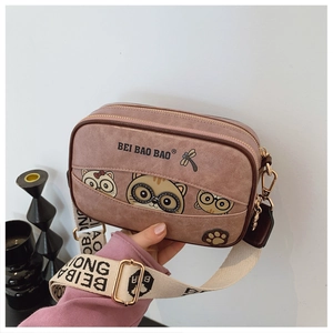 Close-up of pink PU leather bear bag with metal zipper and printed canvas strap
