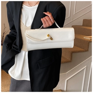 Macro shot of glossy white patent leather surface and luxury gold twist-lock on handbag