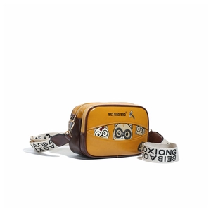 Detail view of cartoon bear crossbody bag with yellow finish and adjustable woven strap