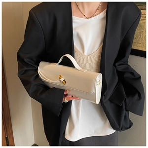 Detailed close-up of a glossy cream handbag with a gold rotary lock and top handle