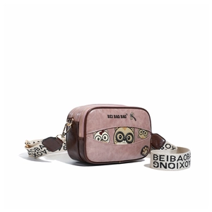 Close-up of pink leather box bag with cute cartoon cat print and wide woven strap