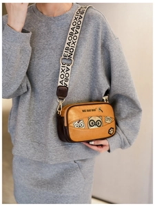 Detail of cute yellow bear-themed crossbody bag featuring a wide patterned shoulder strap