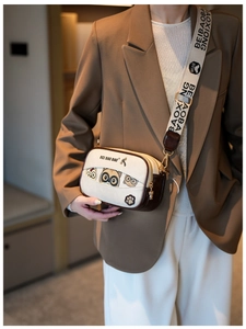 Detail of cute cat pattern on beige crossbody box bag with bear charm and wide strap