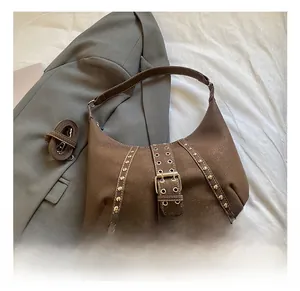 Dettaglio della borsa hobo in pelle scamosciata marrone con borchie dorate