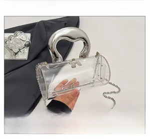 Detail view of transparent acrylic cylinder bag with silver metal handle and chain strap