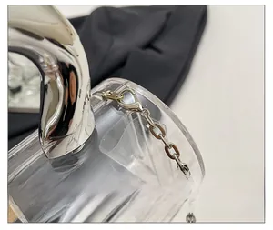 Close-up of silver metal lobster clasp and high-gloss handle on acrylic cylinder bag