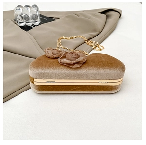 Detail der herzförmigen Samt-Clutch in Hellbraun mit Goldrahmen und Stoffrosen
