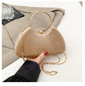Detail der Champagner-Samt-Clutch mit goldener Rundgriff- und Kettenriemen-Veredelung