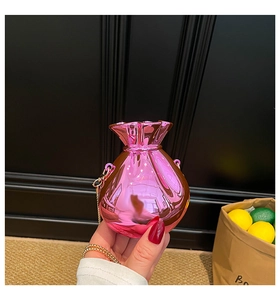 Detail der metallisch-pinkfarbenen Mini-Geldtasche mit goldener Kette und Spiegeleffekt