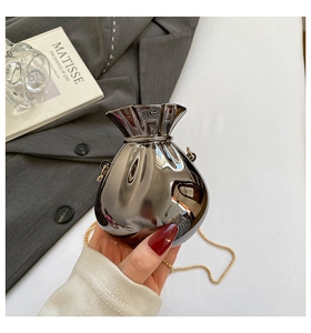 Nahaufnahme einer silbernen Mini-Tasche im Glücksbeutel-Design mit goldener Kette
