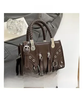 Detail of brown faux leather shoulder bag with rivet studs and woven handle