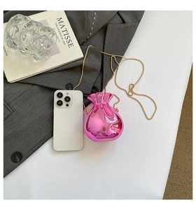 Mini-Acryl-Geldbeutel in glänzendem Pink mit Goldkette neben einem Smartphone
