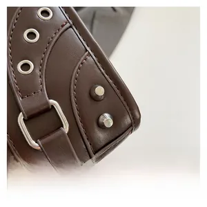 Macro shot of brown pebble leather texture with metallic studs and silver-tone hardware