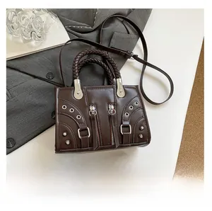 Macro view of coffee brown crossbody bag with woven handle and silver rivet details
