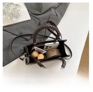 Detail view of large interior storage capacity in dark brown tote bag with woven handles