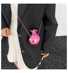 Detail der metallisch rosa Mini-Geldtasche mit Kordelzug und goldener Kette am Modell