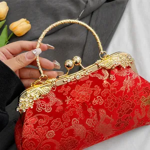 Close-up of golden dragon and phoenix metal clasp with rhinestones on a red silk bag