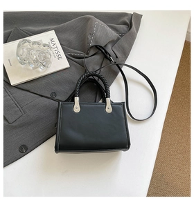 Top-down view of black matte leather rivets tote bag with woven handles and silver hardware